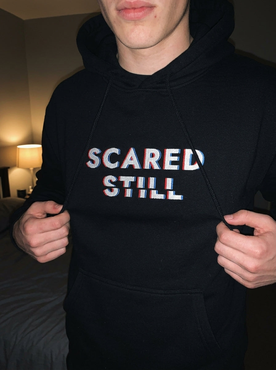 Close-up of the SCARED STILL chest embroidery